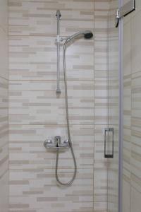 a shower with a shower head in a bathroom at MAGNIFIKSTYLE - Alojamento Local 1 in Guarda