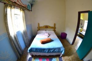 a bedroom with a bed and a large window at Hostel Tiradentes in Tiradentes