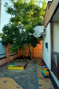 a backyard with a tree and a play area at Три кошки in Chornomorsk