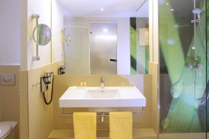 a bathroom with a sink and a shower at Hotel PreMotel-Premium Motel am Park in Kassel