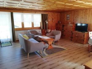 a living room with chairs and a table and a tv at Chalet Hedy Ferienwohnung in Grächen