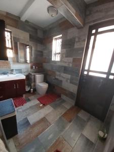 a bathroom with a toilet and a sink and a door at Letaba Cottages in Johannesburg