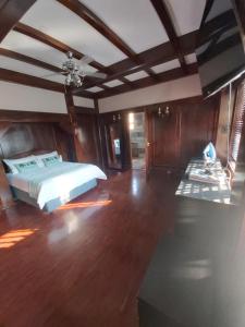 1 dormitorio con 1 cama y suelo de madera en Letaba Cottages, en Johannesburgo