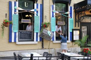 una mujer está parada fuera de un restaurante en Hotel Clarendon, en Quebec