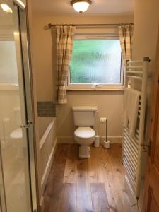 a bathroom with a toilet and a window at East Park B&B in Roybridge