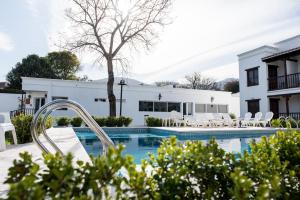 una piscina frente a una casa blanca en Posada de los Poetas Hotel Boutique en San Lorenzo