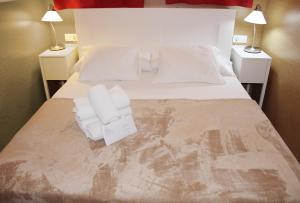 a bed with white pillows and towels on it at Aloe Friendly Holiday Home in Playa del Ingles +21 photos