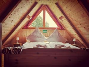 Bett in einem Holzzimmer mit Fenster in der Unterkunft Ferienhaus am Radwanderweg in Klausdorf