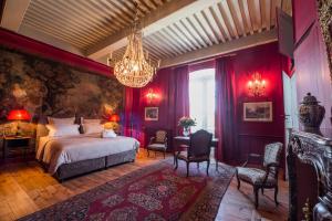 a bedroom with a large bed and a chandelier at Domaine de Chalaniat in La Sauvetat