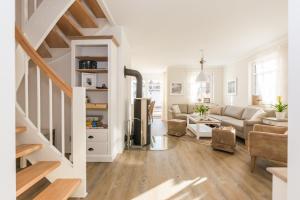 a living room with white walls and a staircase at Sanddollar in Zingst