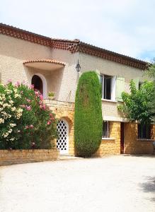 une maison avec un grand bush devant elle dans l'établissement les oliviers, à Carpentras