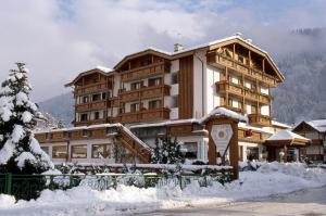 a large building with snow in front of it at Olympic Palace in Pinzolo