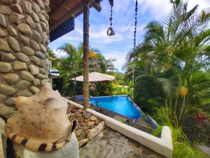 a swimming pool next to a building with a resort at Horizon Hotel & Yoga Center in Santa Teresa Beach