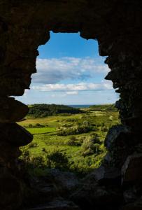 a view of a field through a stone window at The Knock Guest house in Dunhill