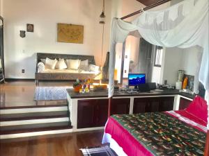 a bedroom with a bed and a desk with a laptop at Luxury Villa Casa do Sol in Búzios