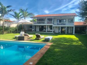 a house with a swimming pool in front of it at Luxury Villa Casa do Sol in Búzios