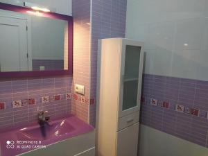 W łazience znajduje się różowa umywalka i lustro. w obiekcie Apartamento Santa Ana Ronda w mieście Ronda