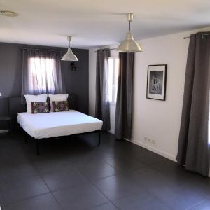 1 dormitorio con 1 cama blanca y 2 ventanas en Holiday house Mont Ventoux with Spa, en Entrechaux