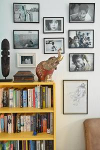 a book shelf with books and pictures on a wall at Lemongrass Hostel in Limassol