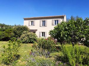 ein weißes Haus inmitten eines Gartens in der Unterkunft Holiday house Mont Ventoux with Spa in Entrechaux