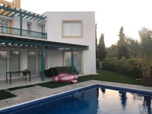 a house with a swimming pool in front of a house at Oasi Rejuve Poseidon in Meneou