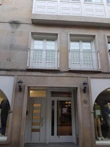 een gebouw met drie ramen en een deur met een balkon bij Barcia 3 in Pontevedra