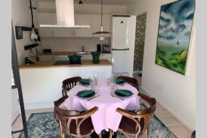 a kitchen with a table with a pink table cloth at Lejlighed på Torvet i Stege in Stege