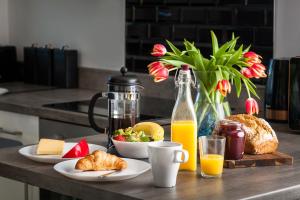 a table with breakfast foods and a jug of orange juice at Curragh House Lodges in Kinsale
