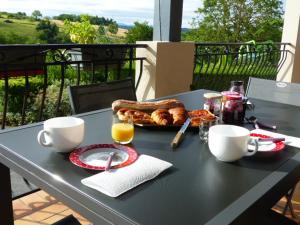 Suite hauteurs de Vichy في Creuzier-le-Vieux: طاولة سوداء مع طبق من الطعام والقهوة