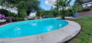 una piscina de agua azul en un patio en B&B Knooppunt70 en Arcen