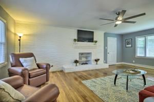 ein Wohnzimmer mit einem Sofa und einem TV an der Wand in der Unterkunft Serene Home on Pond - 5 Mi to Dtwn Greensboro in Greensboro