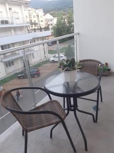 a table and chairs on a balcony with a table and a potted plant at Đurđevak lux in Banja Koviljača