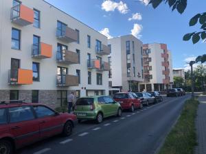 rząd samochodów zaparkowanych na ulicy obok budynku w obiekcie Apartament Avanti z Klimatyzacją i Garażem w Toruniu