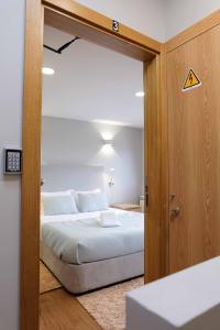 سرير أو أسرّة في غرفة في MAGNIFIKSTYLE - Alojamento Local 3
