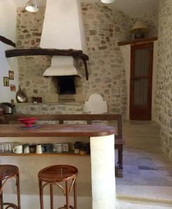 eine Küche mit Holzhockern und einem Tisch mit einem Herd in der Unterkunft La Maison de Vergol in Montbrun-les-Bains