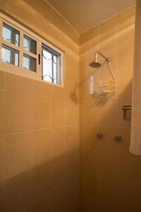 ein Bad mit einer Dusche und einem Fenster in der Unterkunft Casa Zac Nicte Mx-Habitacion IXCHEL in Cancún