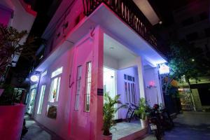 ein Gebäude mit rosa und lila Lichtern in der Unterkunft 5.T Hostel in Hue