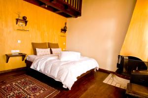 a bedroom with a bed with white sheets and a tv at Mansion of Kerkini in Kerkini