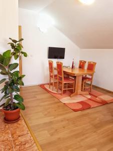 a dining room with a wooden table and chairs at Apartman Lukić in Korenica