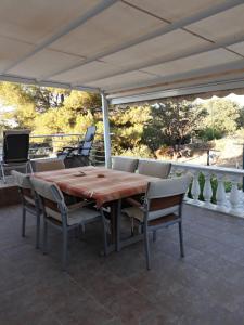 a wooden table and chairs on a patio at Apartment Tuja in Jadrtovac