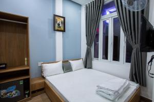 ein kleines Schlafzimmer mit einem Bett und einem Fenster in der Unterkunft 5.T Hostel in Hue