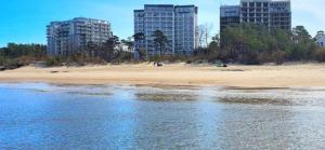 a beach with two tall buildings in the background at LUX Apartment KARINA in Dziwnówek
