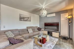 a living room with a couch and a tv at le panorama du lac in Annecy