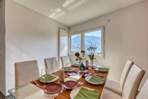 a dining room with a table and chairs and a window at le panorama du lac in Annecy