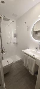 a bathroom with a toilet and a sink and a shower at Hotel Gran Proa Playa Raxó in Raxo