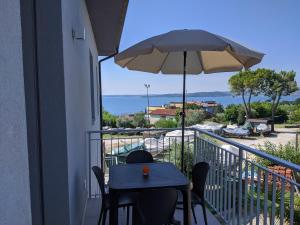 a table and chairs on a balcony with an umbrella at Villa Molino in Moniga