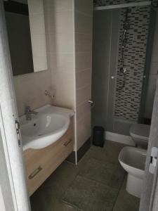 ein Bad mit einem Waschbecken und einem WC in der Unterkunft Happy Family B&B in Viggianello