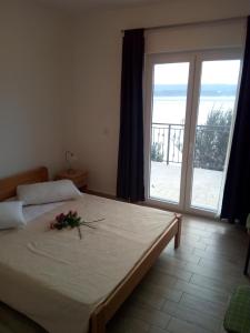 Un dormitorio con una cama con una flor. en Apartment on the beach en Lokva Rogoznica