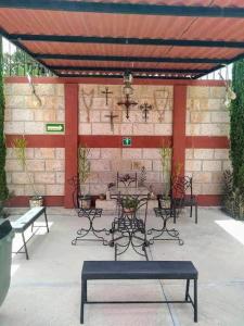 um pátio com mesas e cadeiras e uma parede de tijolos em Hotel Mirador Real em Bernal