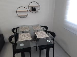 une table en verre avec deux chaises et deux miroirs dans l'établissement lovely apart 3 minutes to the beach, à Torrevieja